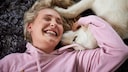 Eine Frau kuschelt mit einem Hund