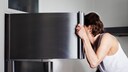 Frau vor Eisschrank