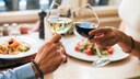 Paar stößt mit Rot- und Weißwein an