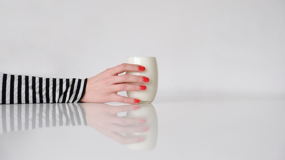 Frau hält Glas Milch in der Hand