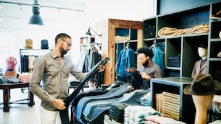 Mann schaut sich Jeans im Geschäft an