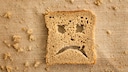 Toastscheibe mit traurigem Smiley-Gesicht