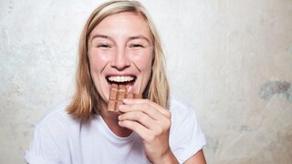 Junge Frau isst Schokolade