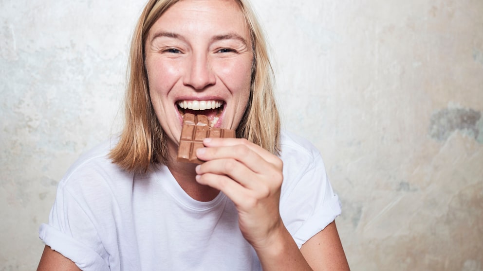 Junge Frau isst Schokolade