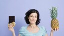 Frau mit Schokolade und Ananas in der Hand