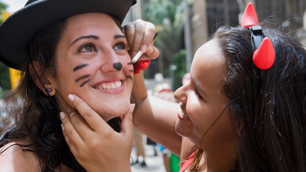 Frauen schminken sich für Karneval