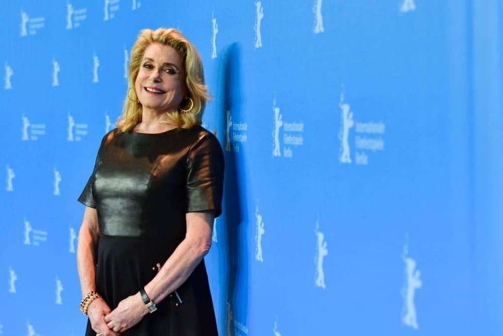 Catherine Deneuve auf dem Roten Teppich in einem schwarzen Kleid.