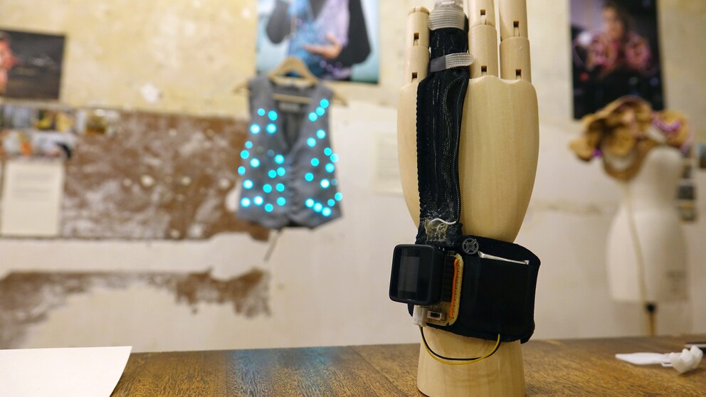 Ein Handmodel mit Fingerprothese steht auf einem Tisch in der Schneiderei für elektronische Textilien