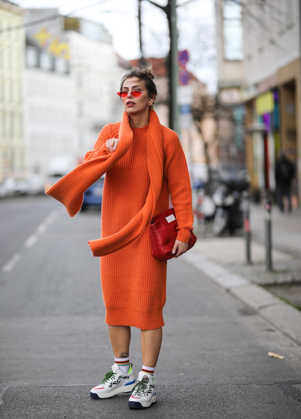 Frau in orangefarbenem Look mit Schal