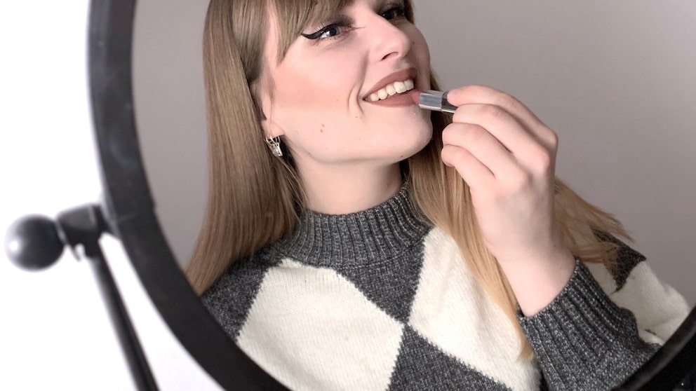 Frau die Lippenstift aufträgt