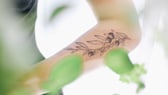 Frau mit Pflanzen-Tattoo