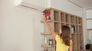 Frau macht Klimaanlage an