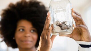 Frau, die eine Geldbüchse in der Hand hält