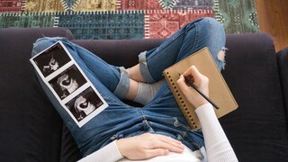 Schwangere Frau auf dem Sofa mit Umstandshose