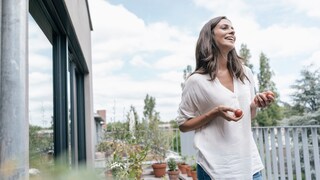 Frau isst Kirschtomaten als Snack