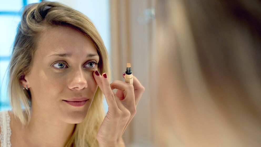 Frau tupft Concealer drauf
