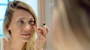 Frau tupft Concealer drauf
