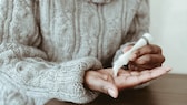 Frau trägt Handcreme auf