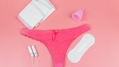 Tampons, Binden und ein Menstruationscup neben einer Unterhose