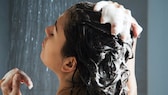 Frau schäumt Haut mit Shampoo ein