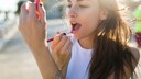 Frau, die Lippenstift aufträgt