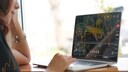 Frau vor Laptop mit Börsenkursen
