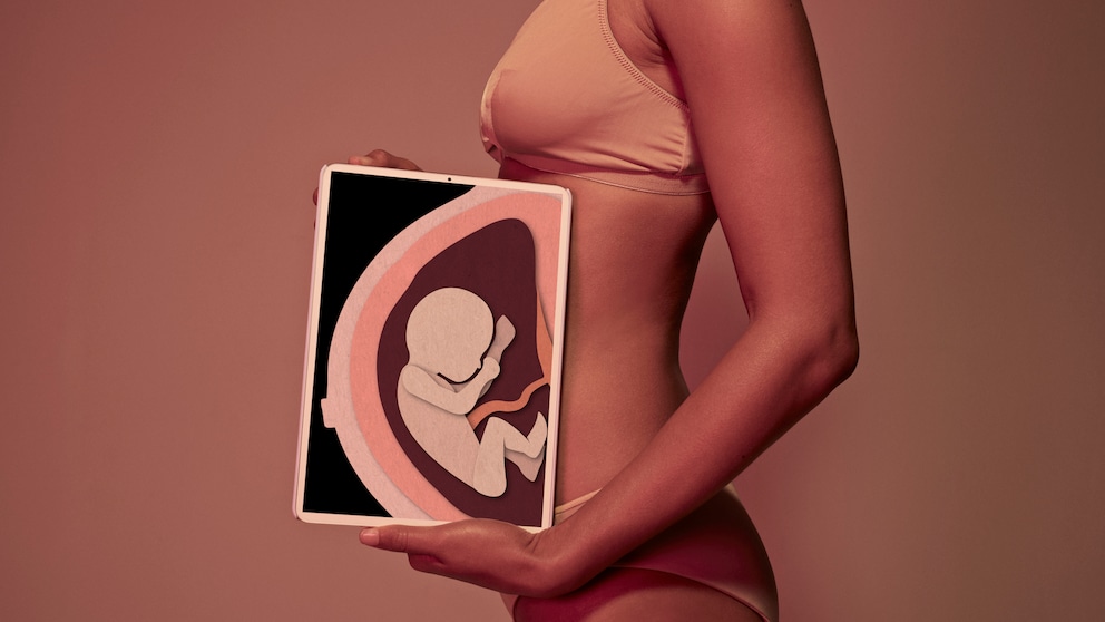 Frau hält vorm Bauch ein Tablet, das eine Röntgenaufnahme eines Babys zeigt