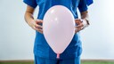 Hebamme mit Luftballon