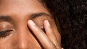 Frau im Close-up, die sich ins Gesicht fasst