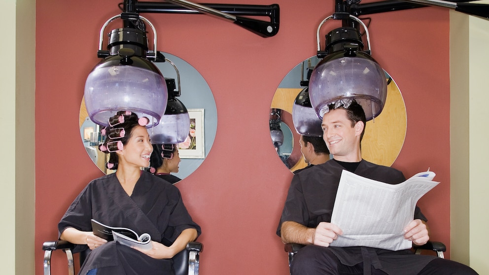 Mann und Frau beim Friseur unter der Trocknungshaube