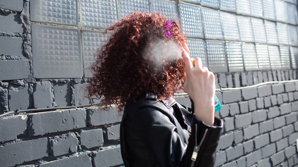 Frau mit Hitzeschutzspray in der Hand