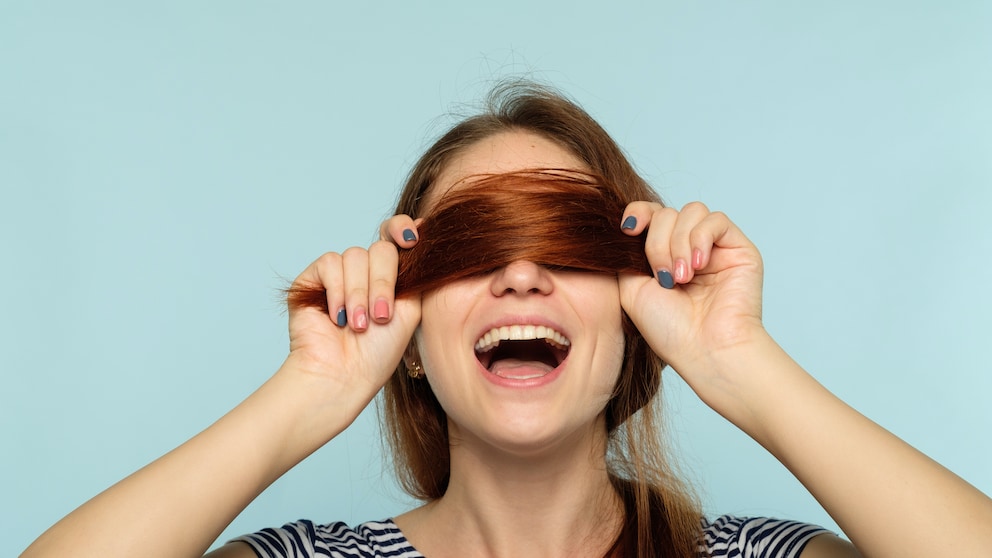 Frau, die sich ihre Haare über die Augen hält