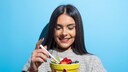 Frau, die aus einer Schale mit Obst isst