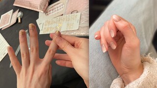 Frau klebt sich Nagelfolie auf