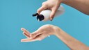 Hand mit Cremeflasche