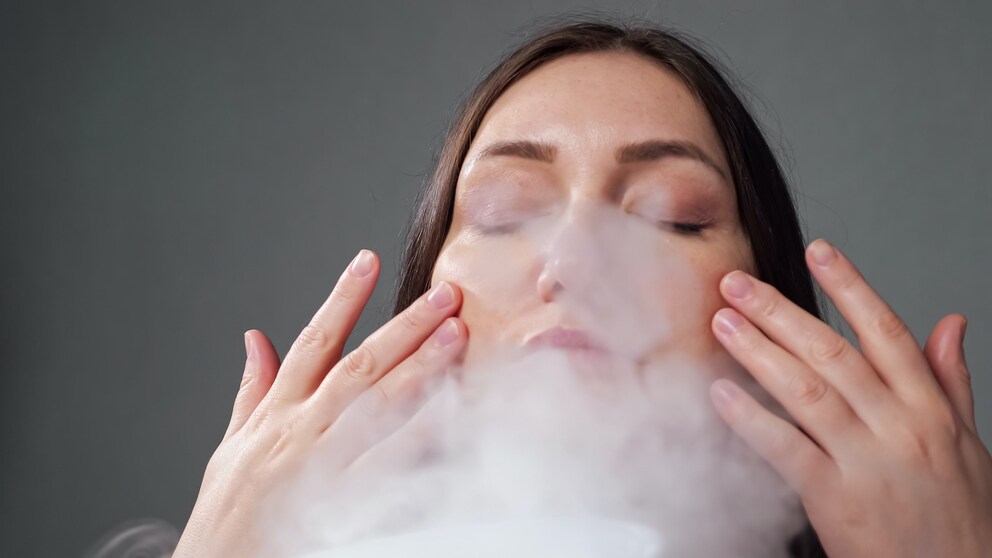 Frau, die einen Facial Steamer benutzt