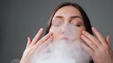 Frau, die einen Facial Steamer benutzt