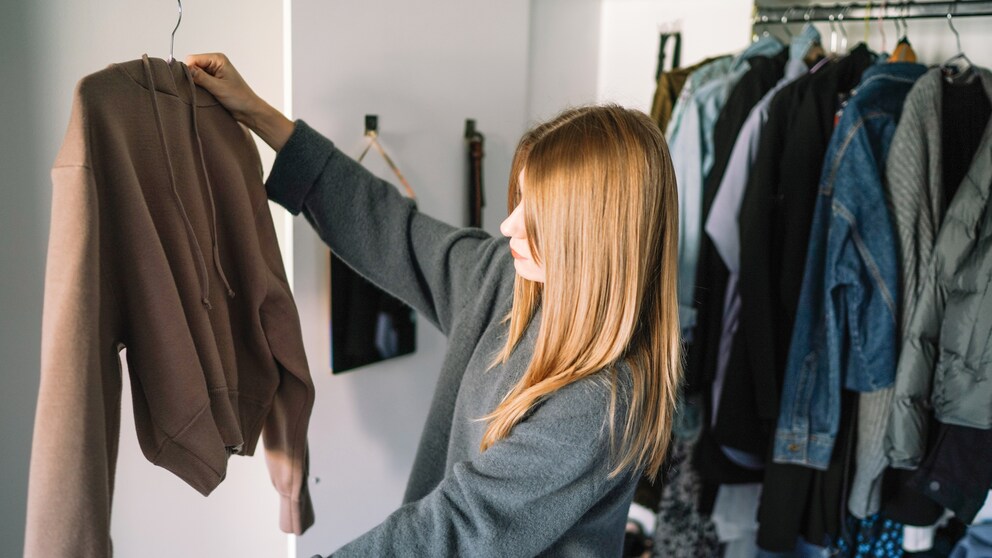 Frau hängst Sachen in ihr Schrank