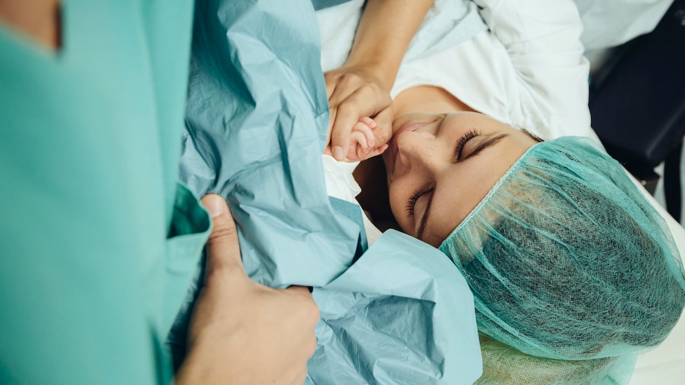 Frau mit Baby nach Kaiserschnitt