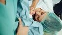 Frau mit Baby nach Kaiserschnitt
