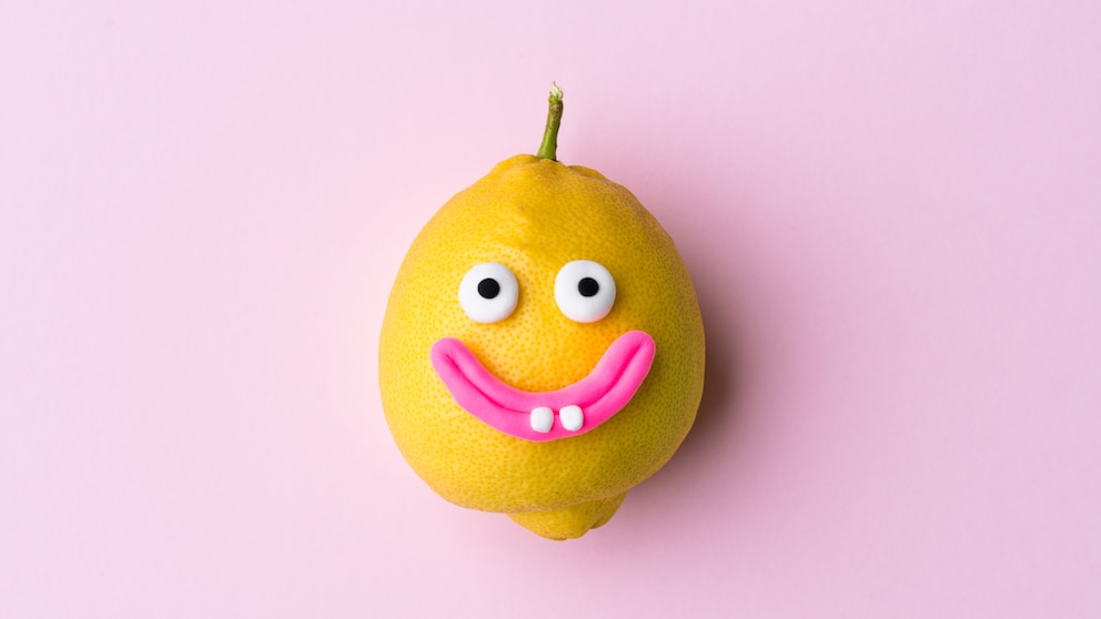Happy lemon fruit with face on pink background