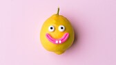 Happy lemon fruit with face on pink background