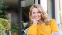 Frau über 50 in einem gelben Pulli