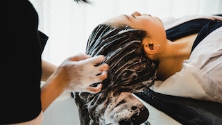 Frau lässt sich die Haare waschen