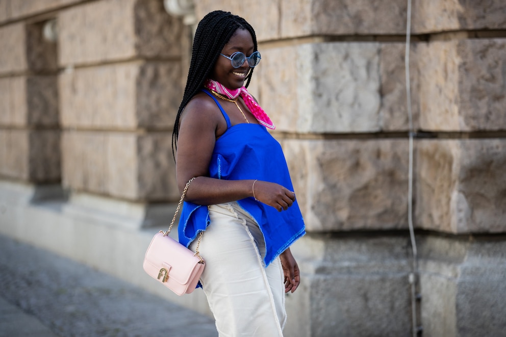 Frau mit blauem Shirt unD Pinker Bandana auf dem Hals