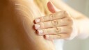 Frau cremt ihre Hand an