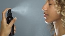 Frau mit Gesichtsspray in der Hand