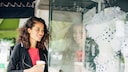 Frau steht vor einem Schaufenster mit Bikini-Mode
