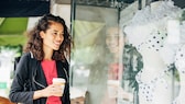 Frau steht vor einem Schaufenster mit Bikini-Mode