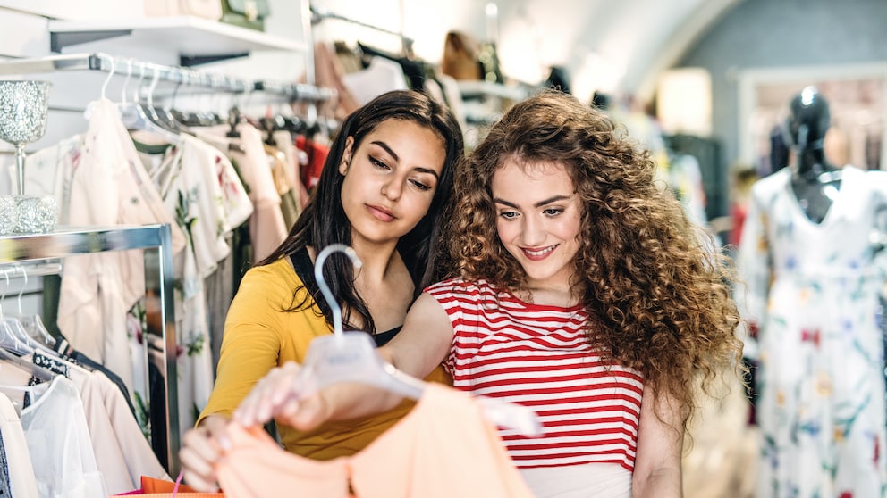 Zwei Frauen gucken sich ein Kleid im Shop an